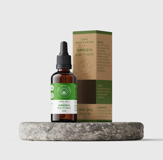 Premium CBD Brothers green edition CBD oil bottle and packaging on circular plinth
