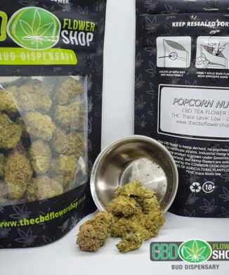 High-quality CBD flower product image spilling out of metal pot in front of packaging with dense and rich texture.