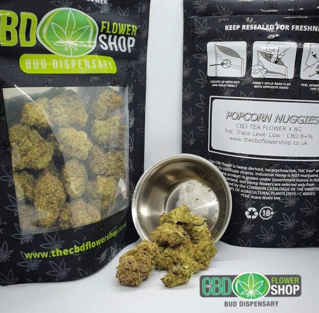 High-quality CBD flower product image spilling out of metal pot in front of packaging with dense and rich texture.