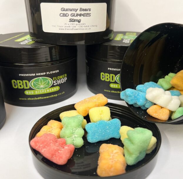 CBD Gummy Bears 50mg spilling out of open pot onto lid