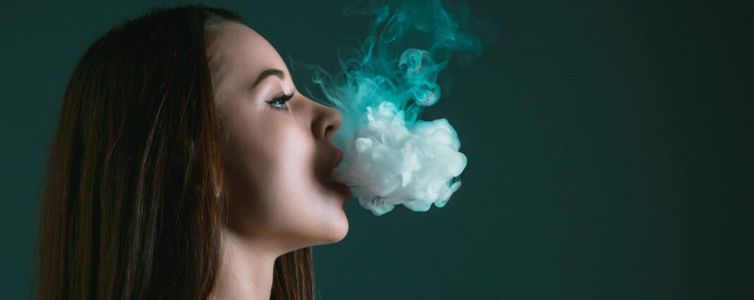 woman breathing out cbd vape