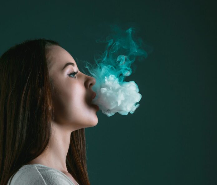 woman breathing out cbd vape