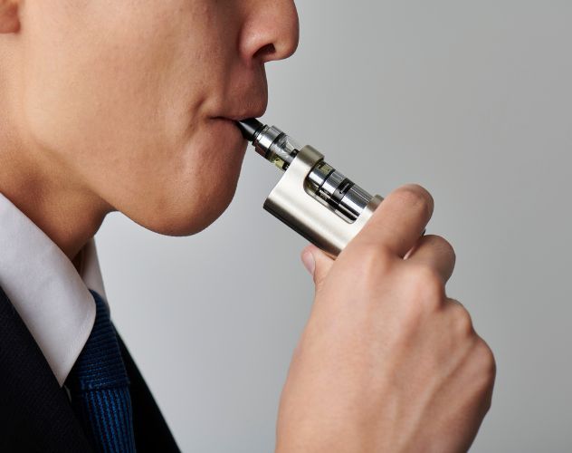 man using silver vape device