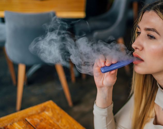 woman vaping in cafe
