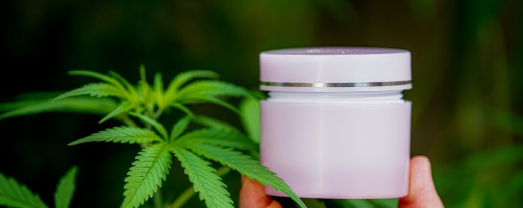 Moisturiser tub held in front of a blant