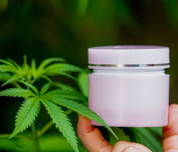 Moisturiser tub held in front of a blant