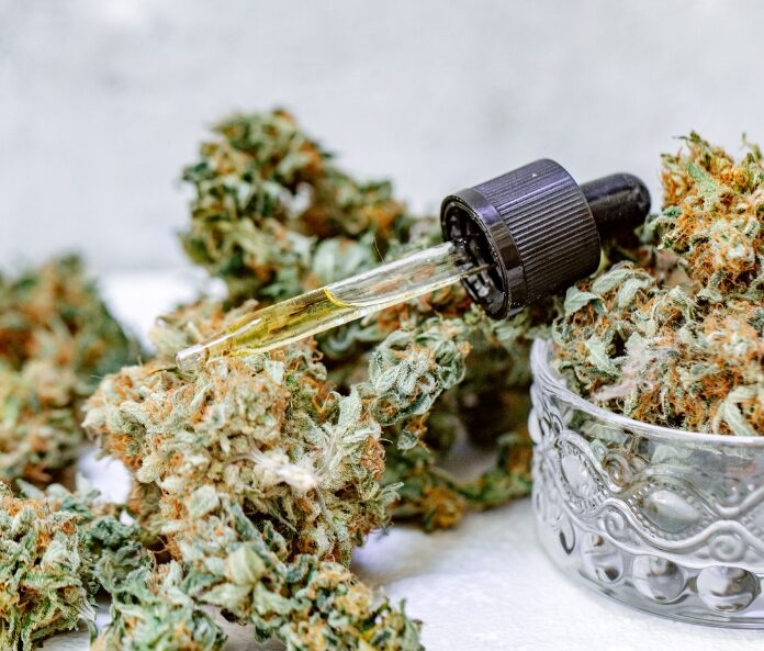 CBD oil dropper place on top of a pile of CBD flower buds