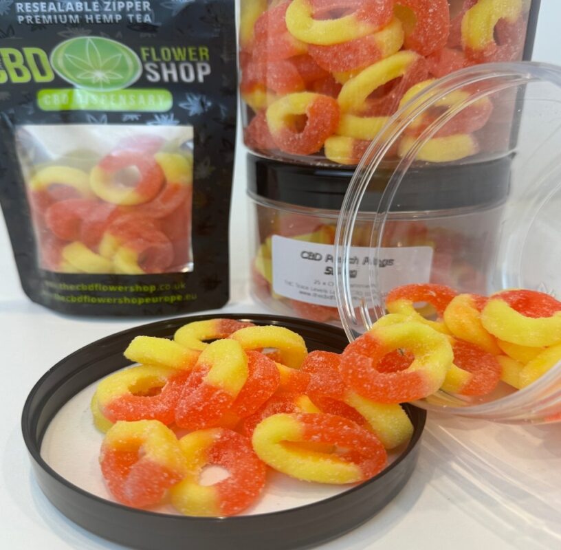CBD Peach Rings Gummies 50mg pouring out of pot onto lid
