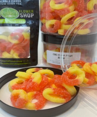 CBD Peach Rings Gummies 50mg pouring out of pot onto lid