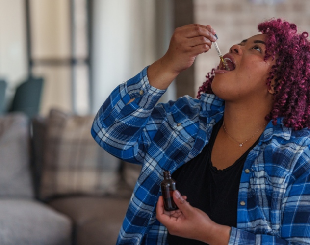 Woman taking CBD oil drops
