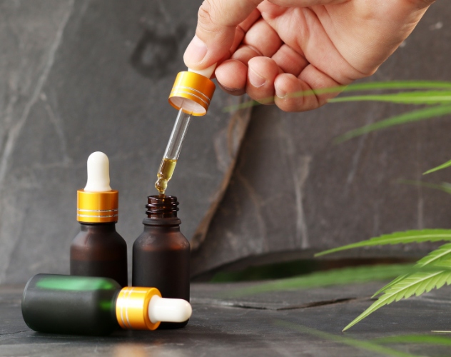 CBD oils with hand pulling out the pipette