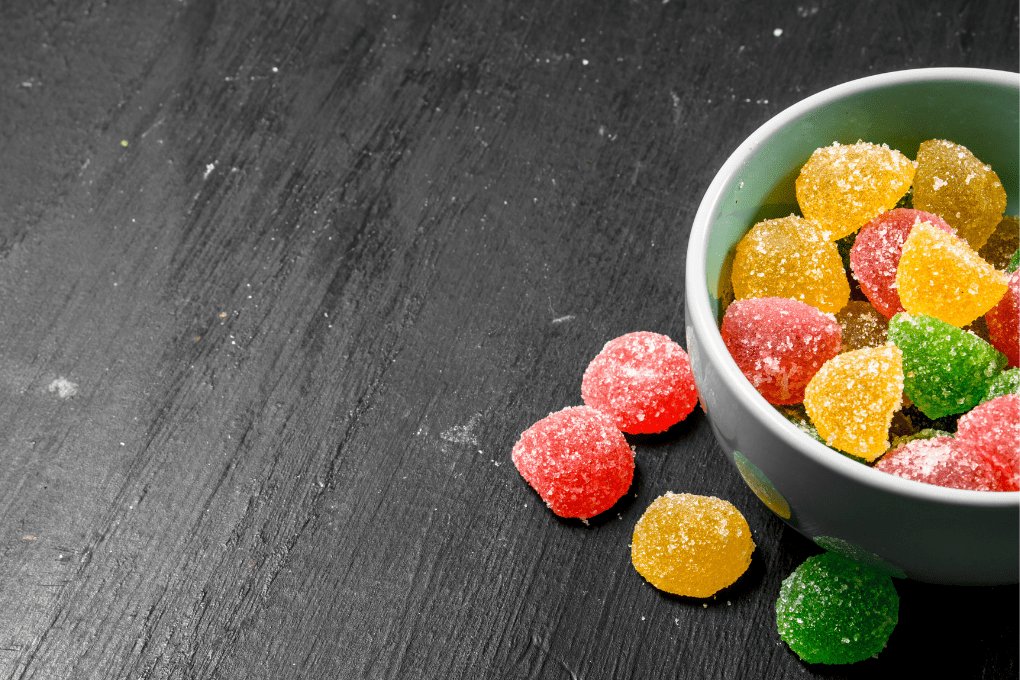 Bowl of CBD gummies on black table