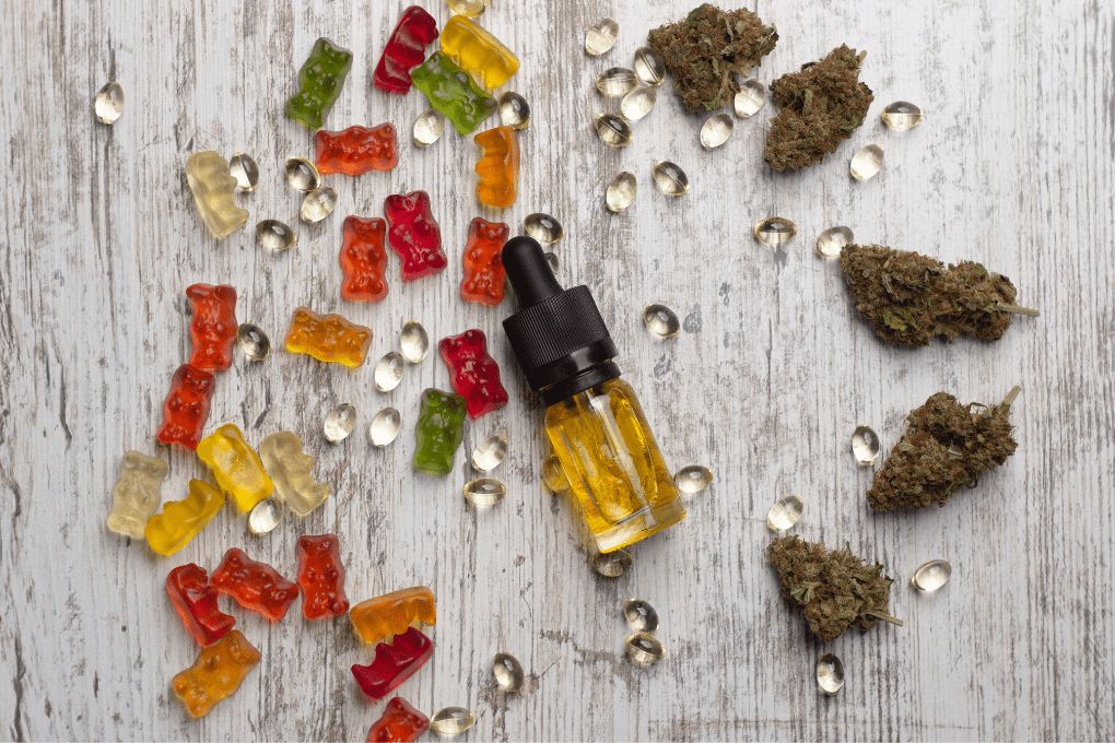 CBD gummies, oil, capsules and CBD flowers on wooden surface