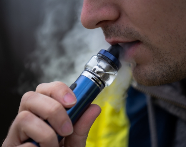 Man inhaling vape pen