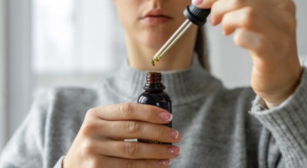 woman opening cbd oil bottle