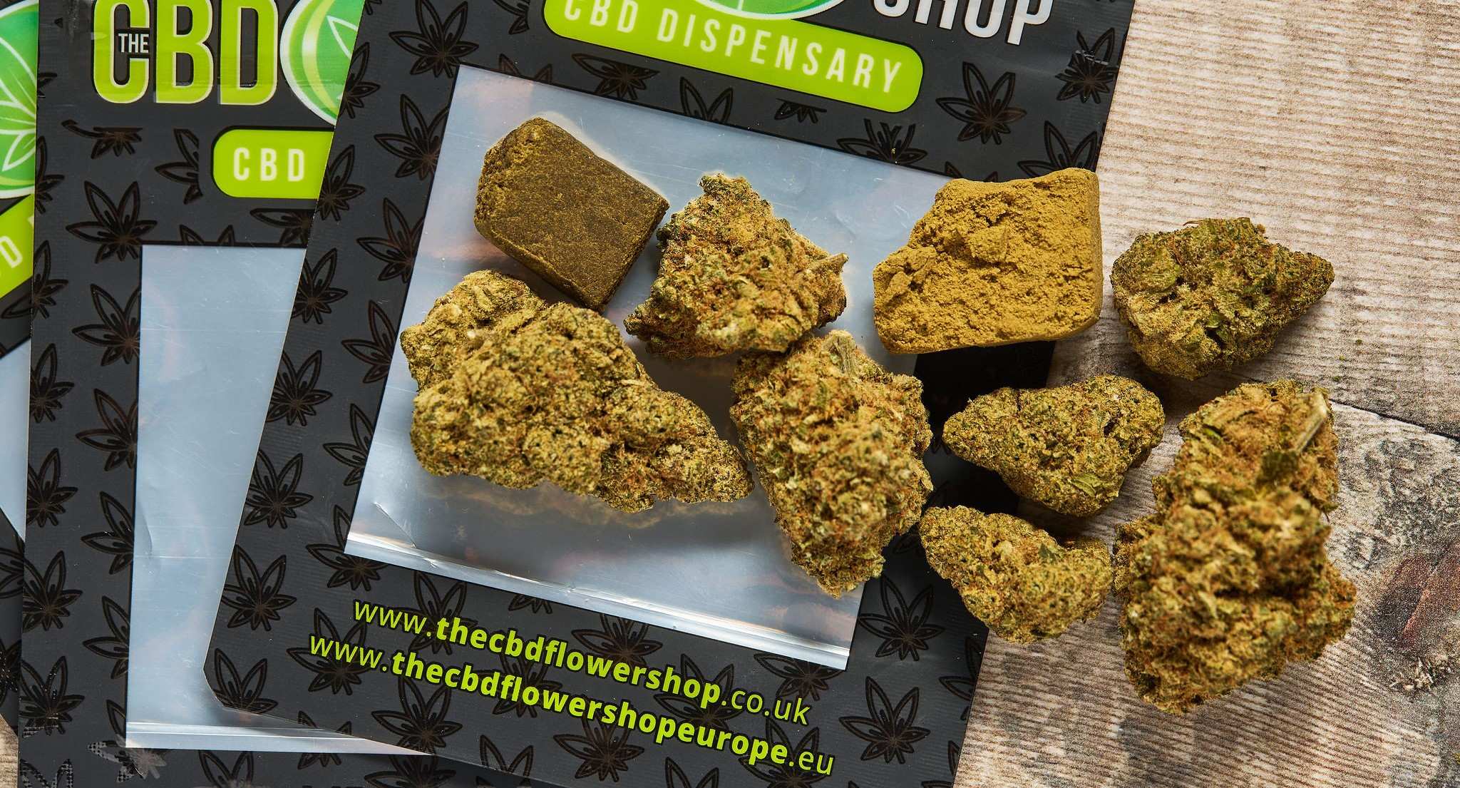 The CBD Flower Shop concentrates and flowers on top of The CBD Flower Shop packaging