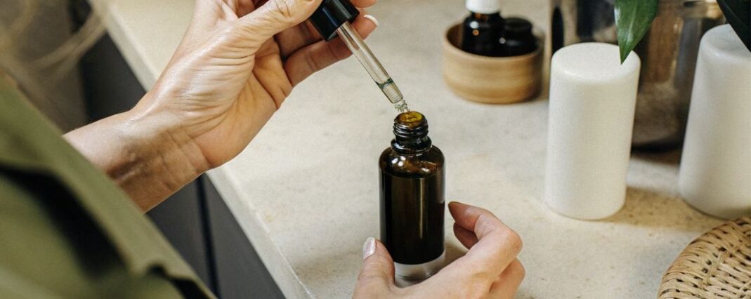 a woman opening a CBD oil bottle on a counter