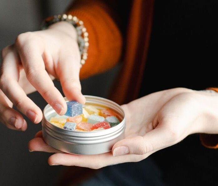 woman taking CBD gummies for pain relief