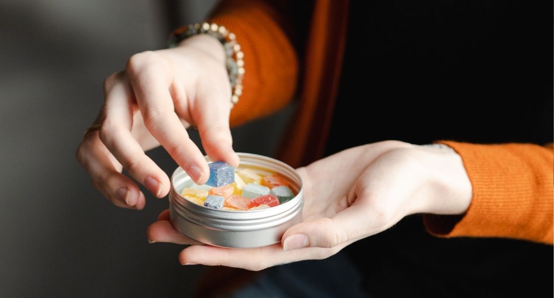 woman taking CBD gummies for pain relief