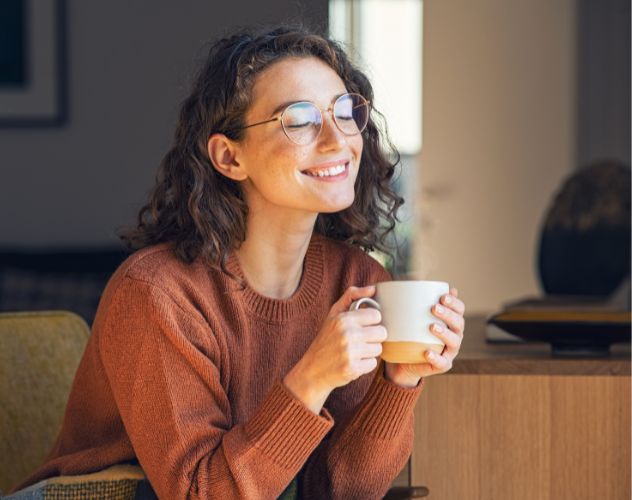woman smiling holding a cup of tea