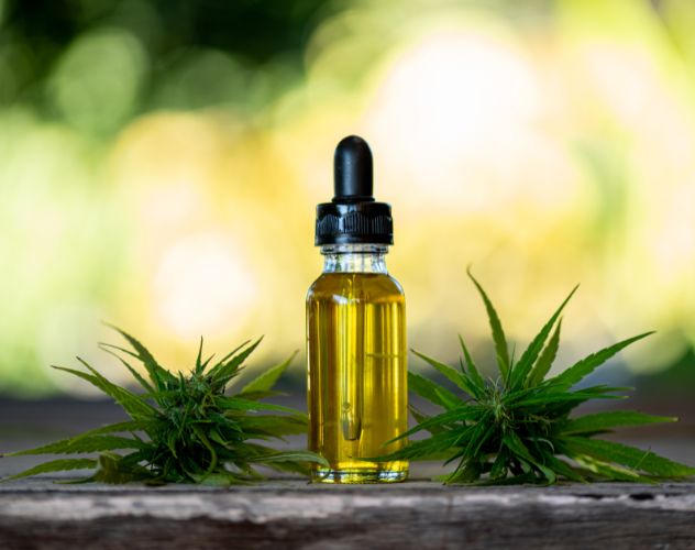 oil dropper bottle of cbd oil outside on wooden ledge