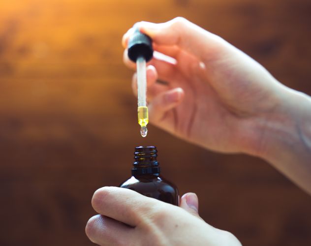 hands opening oil dropper bottle