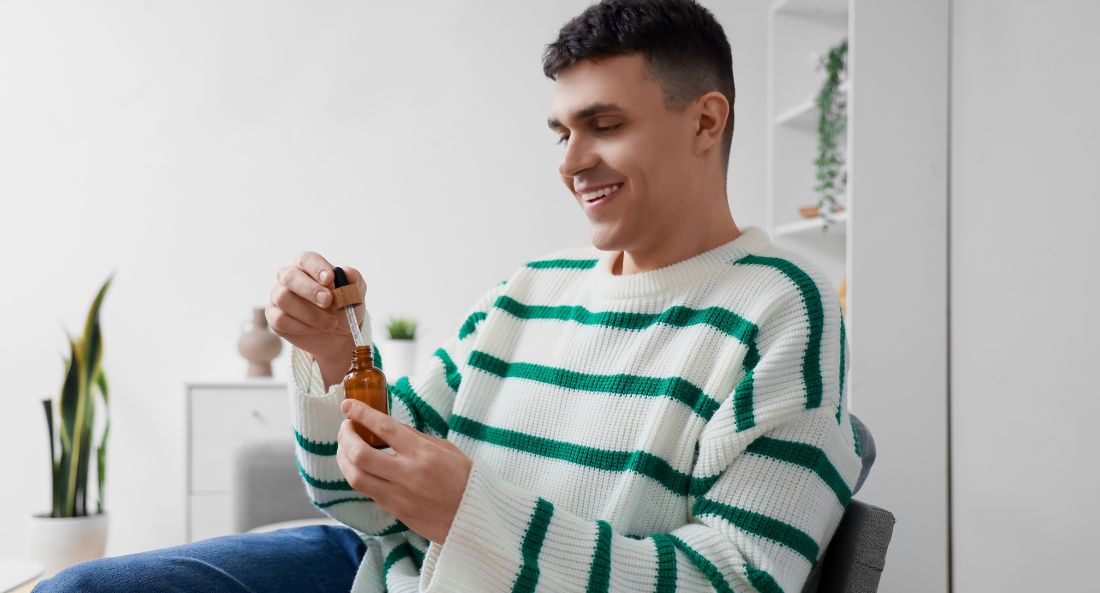 man smiling opening a bottle of cbd oil