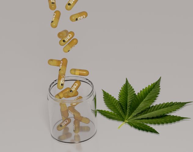 cbd capsules falling into a glass jar next to a hemp leaf