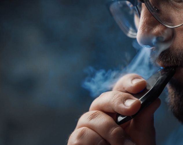 close up of a man vaping with a vape pod