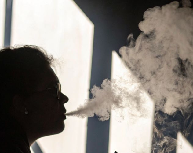 shadow of person vaping with smoke coming out their mouth