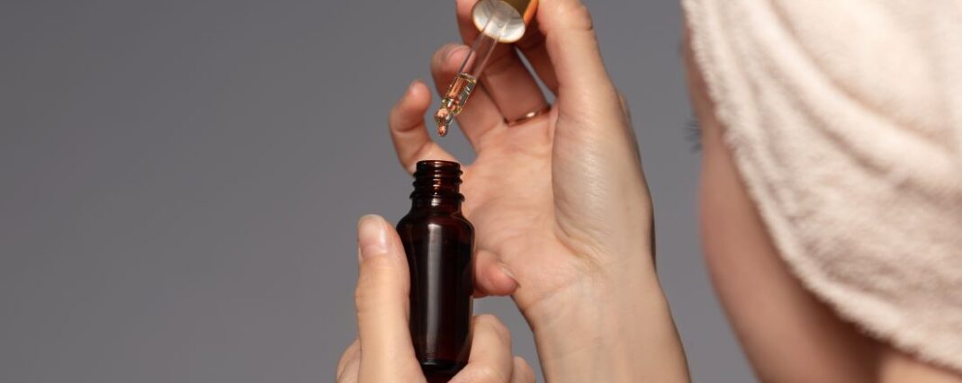 woman opening a bottle of face serum