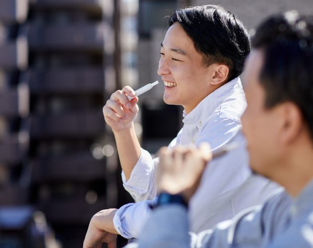 man smiling enjoying cbd vape in city