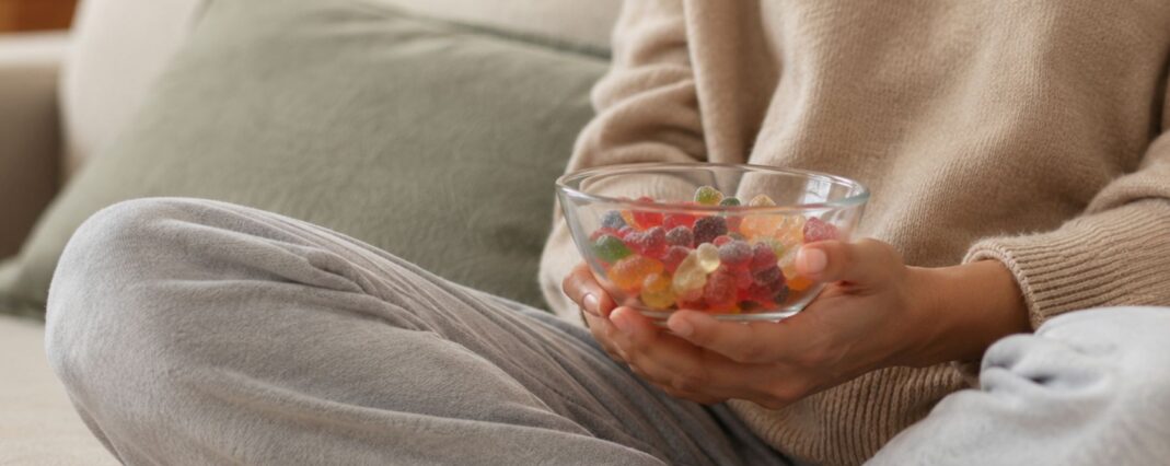 woman holding a bowl of gummies on the sofa