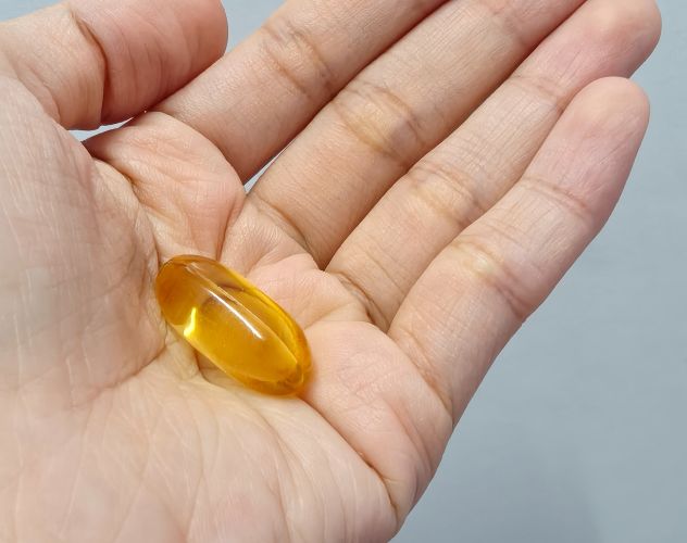 a single cbd oil capsule in the palm of a hand